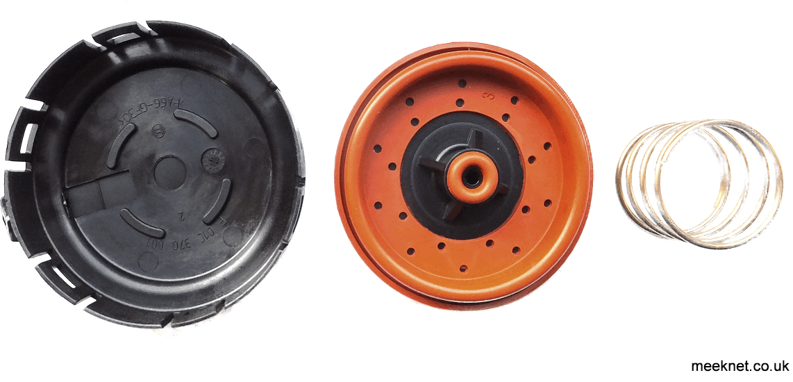 The rear cover has been removed on this PCV, revealing burnt oil and a